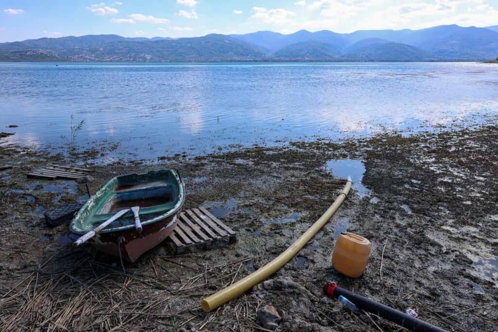 Göl kenarında eski tekne, su pompası ve doğa manzarası, doğal güzellikler ve su aktiviteleri ile ilgili rekabetçi SEO içerik.